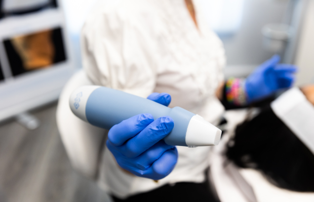 A provider at Vitality Medical Wellness Center showing the photographer the handpiece they use when they administer Exion in Belle Meade.