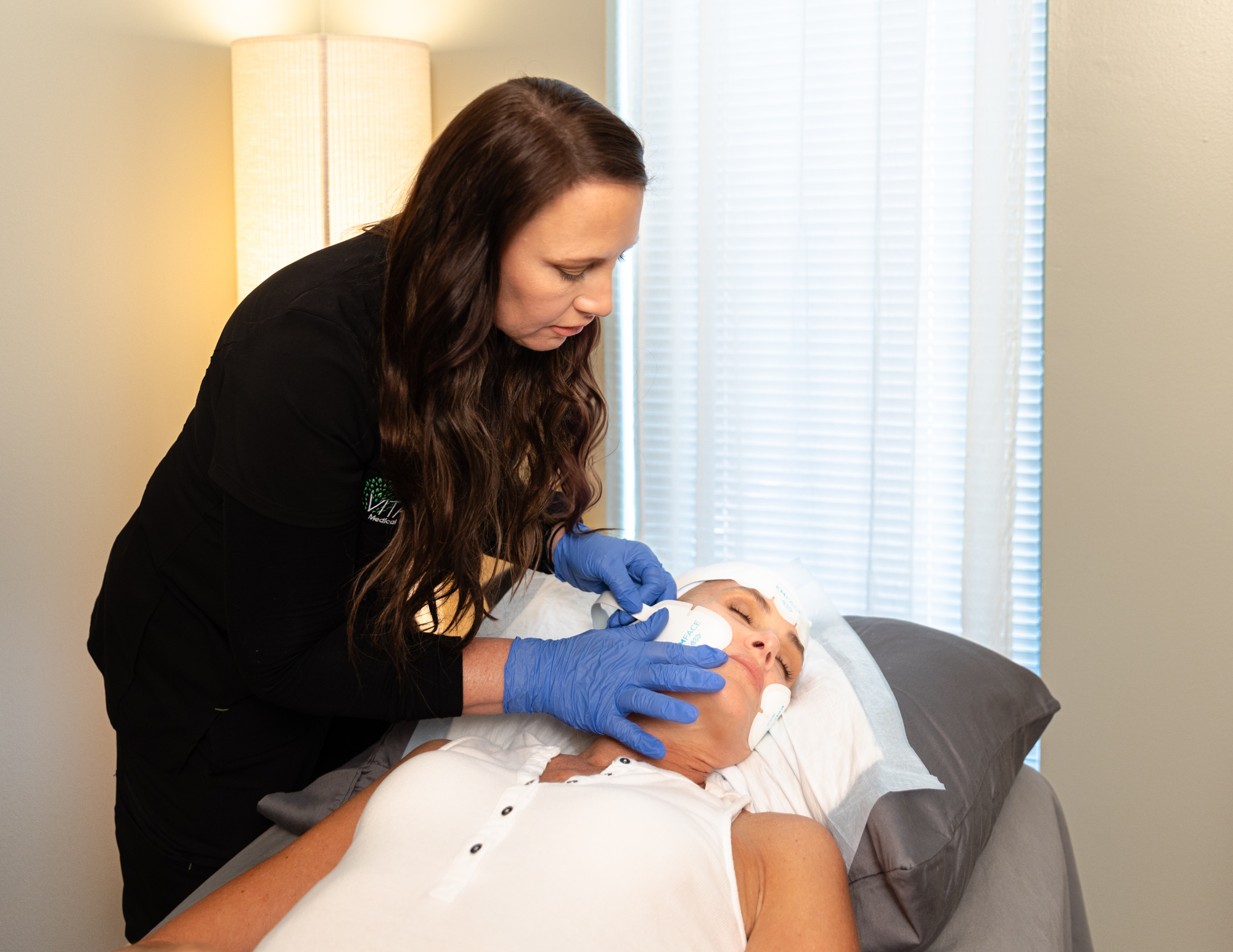 female provider at Vitality Medical Wellness Center beginning to administer treatment for Emface in Belle Meade, TN.